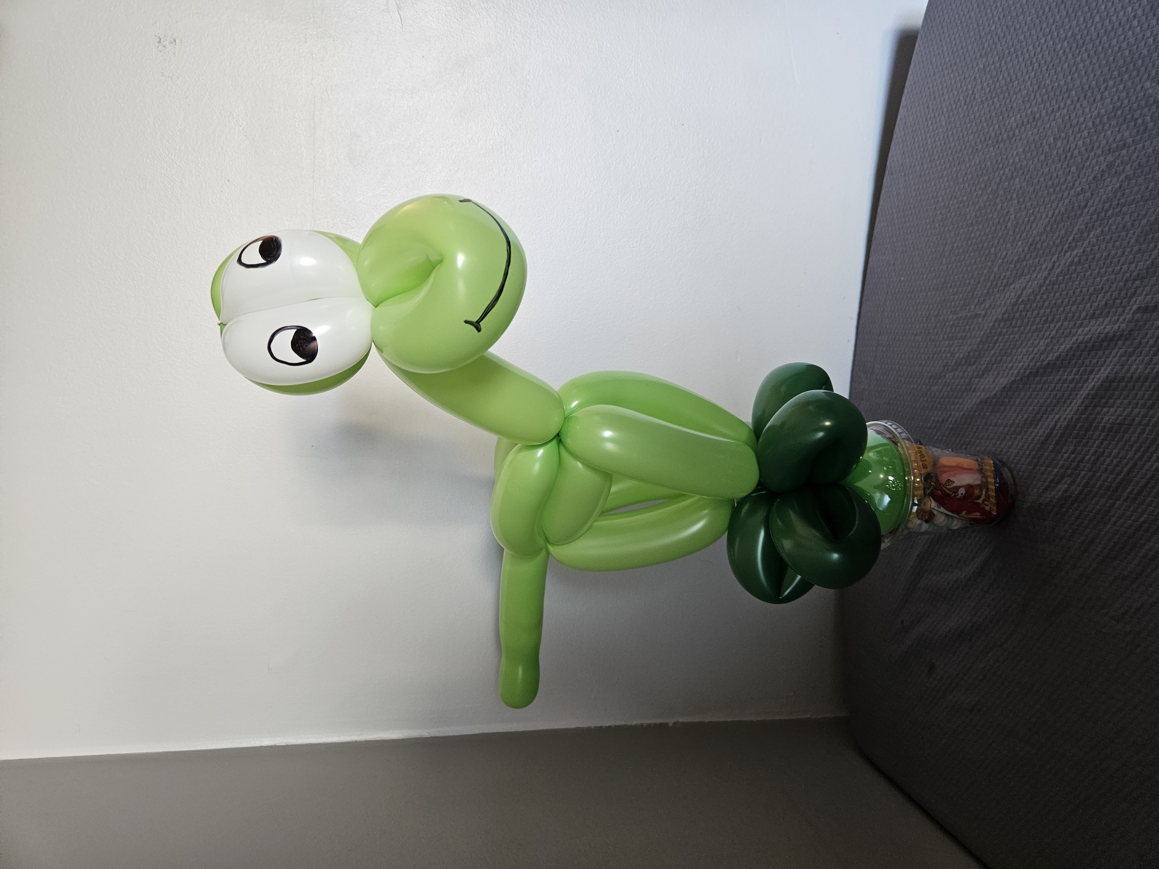 green balloon dinosaur on a candy cup